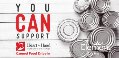 You can support Heart + Hand Outreach Ministries Canned Food Drive-In. Photo of cans on white wood background. Element Federal Credit Union logo