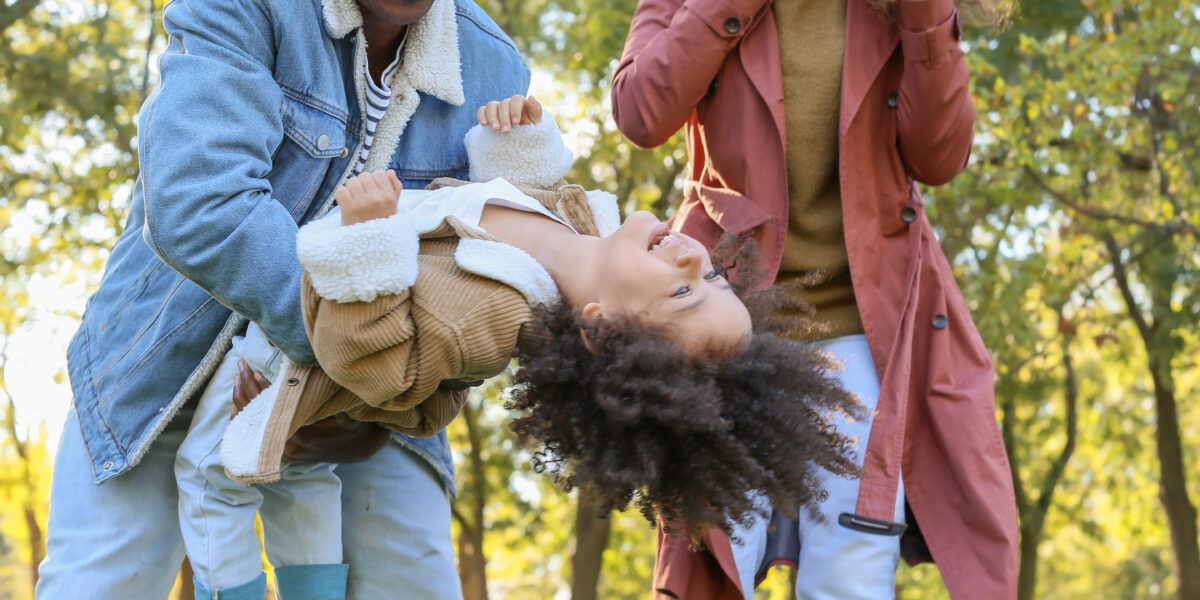 Black family playing with child outside