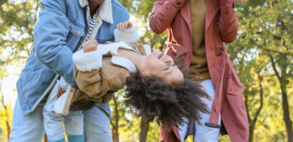 Black family playing with child outside
