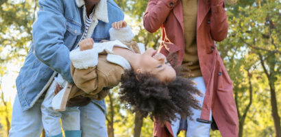 Black family playing with child outside