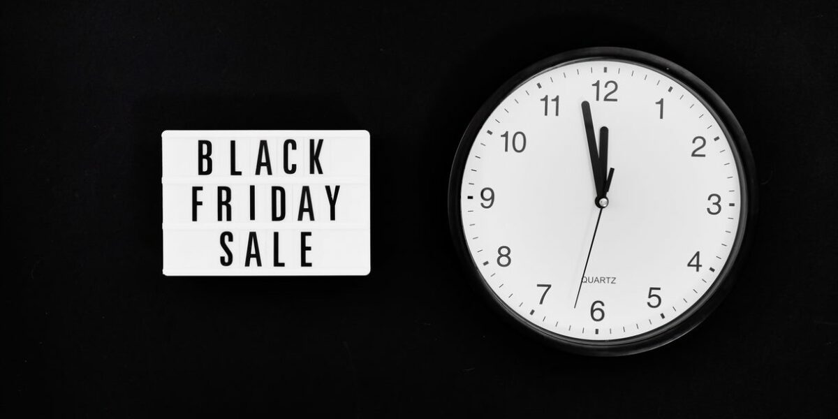 Black Friday Sale sign next to clock on background